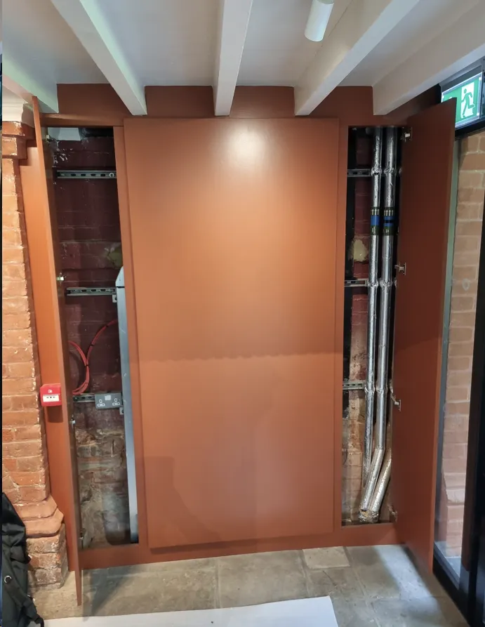 Behind-the-scenes custom metal frame installation by AEC to support the artwork